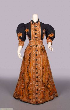 Wool wrapper resist dyed & printed in paisley & phoenix motif w/ shirt collar, CF partial opening, fitted W, 3/4 length puff sleeves & pleated slightly trained skirt, most likely Mulhouse, B 34”, W 25”, L 57”, (0.25” & 0.75” tears CF bodice, 0.75” tear CB collar, 1” seam opening & few sm wear spots W, scattered tiny-0.5” holes and 0.5”-1” light stains in skirt, lower skirt & cuff lining shattered, wear to buttons & buttonholes, bodice lining damaged w/ some repairs/alterations) Very Good 1800s Womens Fashion, 1890s Dress, Gold Outfits, 1870s Fashion, Victorian Dresses, Tea Gown, Period Clothing