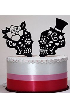 two sugar skulls on top of a cake