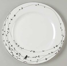 a white plate with black birds on it and wires running across the rim, as well as two smaller plates