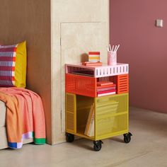 a small colorful cart next to a bed in a room