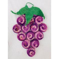 crocheted purple donuts with green leaf on white tablecloth, ready to be used as decoration