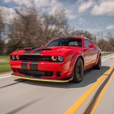 a red sports car driving down the road