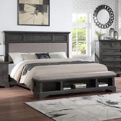 a bedroom with a bed, dresser and night stand in it's center area