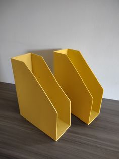 two yellow bookends sitting on top of a wooden table next to each other