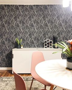 a dining room table with chairs and a plant in a pot on top of it