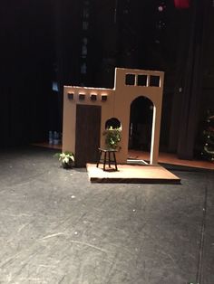 the stage is set up for a play with an arch and small house on it