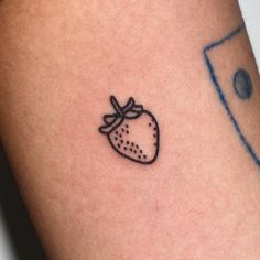 a small strawberry tattoo on the arm