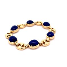 This modern bracelet is crafted in 18 karat yellow gold. A unique and eye-catching piece, this bracelet features beautiful cabochon lapis lazuli stones with a puffy mariner link design. The cabochon lapis lazuli stone has an impressive total weight of 36.90 carats. The perfect statement piece, this bracelet is ideal for any look. Luxury Lapis Lazuli Bracelet Jewelry, Gold Lapis Lazuli Bracelet With Gemstone, Yellow Gold Lapis Lazuli Jewelry With Polished Finish, Yellow Gold Lapis Lazuli Cabochon Jewelry, Luxury Lapis Lazuli Cabochon Jewelry, Modern Bracelets, Lapis Lazuli Stone, Metal Shop, Shop Engagement Rings