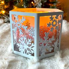 a paper snowflake candle holder sitting on top of a white furnishing