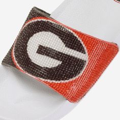 These Georgia Bulldogs Women's Big Logo Shimmer Slides are the jewel of fresh fan footwear! Let your team spirit shine like a beacon of awesome! Features Team-colored design with team logo display on strap, in case there were any doubts where your allegiances lie Shiny tiles on top of strap to make your fandom shine Miniature team logo display on heel of footbed for a little extra fandom Slip-on style with open-toe design, so you can stay cool in the heat of competition, or at the beach Details Beach Details, Logo Display, The Jewel, Georgia Bulldogs, Toe Designs, Lululemon Logo, Team Spirit, The Heat, Team Logo