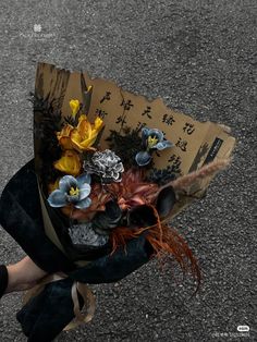 a woman holding a bouquet of flowers on the street