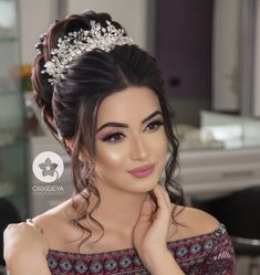 a woman wearing a tiara with flowers in her hair is posing for the camera