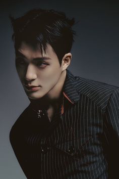 a man with black hair wearing a pinstripe shirt