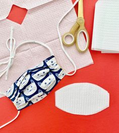 sewing supplies are laid out on a red surface with scissors and other items to sew