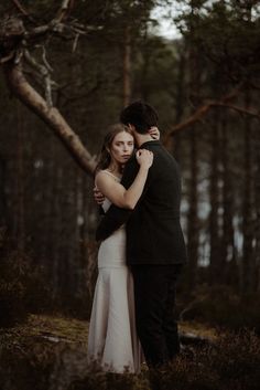 a man and woman embracing in the woods