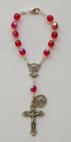 "Precision molded red beads with silver tone metal chain and clasp. SIZE/LENGTH: Total length is 6.75\" including the silver tone Fleur de Lis Crucifix. BEADS: Quality 6 mm beads carefully assembled on a silver tone chain. MEDAL: Saint Christopher Made in Italy Center piece has The Sacred Heart of Jesus and The Immaculate Heart of Mary on the back. The Saint Christopher medal is shown on picture. A Timeless Gift ~ Perfect for any car or truck! This is a very good quality and elegant rosary for u Red Adjustable Rosary With Round Beads, Adjustable Red Rosary With Round Beads, Red Rosary Beads For Jewelry Making, Adjustable Red Rosary, Adjustable Silver Rosary With Faceted Beads, Red Metal Jewelry With Beaded Chain, Adjustable Red Beaded Rosary, Red Beaded Rosary With Round Beads, Silver Rosary With Faceted Beads