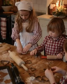 two children are making cookies on a table