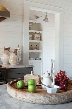 apples and grapes are on a tray in the kitchen