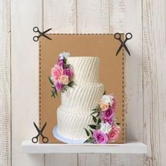 a three tiered cake with flowers and scissors on the top is sitting on a shelf