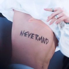 a woman's leg with the word never mind written on it, in black ink