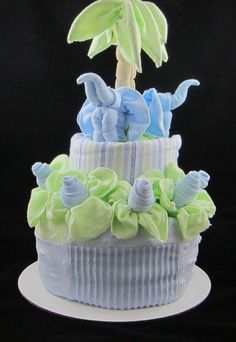 a three tiered cupcake decorated with blue and green frosting, palm tree on top