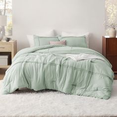 a bedroom with white carpet and green comforter