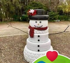 a snowman made out of tires with a red bow on top