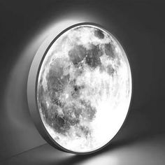 a full moon is shown in the center of a round window with light coming from it