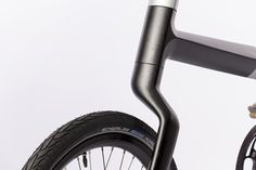 the front wheel of a bicycle with a black handlebar and seat rest on a white background