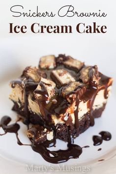 a piece of brownie ice cream cake on a white plate with chocolate sauce drizzled around it