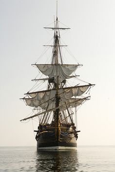 an old sailing ship in the middle of the ocean