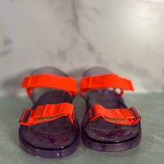 New, Never Worn Purple Open Toe Jelly Sandals For Summer, Orange Non-slip Flat Sandals, Orange Flat Non-slip Sandals, Purple Round Toe Jelly Sandals For Spring, Spring Purple Jelly Sandals With Round Toe, Vacation Sandals With Cushioned Footbed In Purple, Casual Orange Sport Sandals With Round Toe, Casual Purple Slip-on Sandals, Purple Round Toe Sport Sandals For Summer