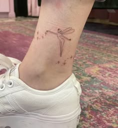 a woman's foot with a small tattoo on the left side of her ankle