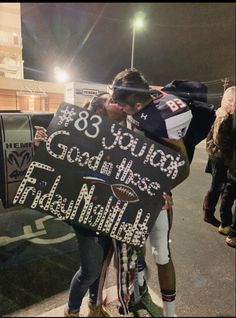 two people kissing each other while holding a sign that reads,'85 years good times friday night '