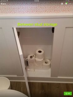 there is a toilet in the bathroom with two rolls of toilet paper next to it