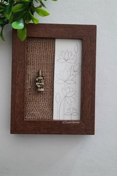 a wooden frame with a flower in the middle and a small bead on it