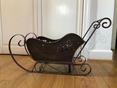 a metal sleigh sitting on top of a hard wood floor