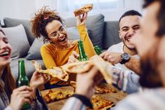 group of friends eating pizza and drinking beer