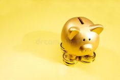 a golden piggy bank sitting on top of stacks of gold coins royalty images and clippings