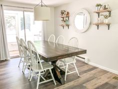 a dining room table with white chairs around it