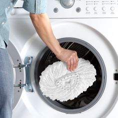 a person is cleaning the front of a washing machine with a cloth on it's side