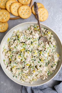 a bowl filled with chicken salad next to crackers