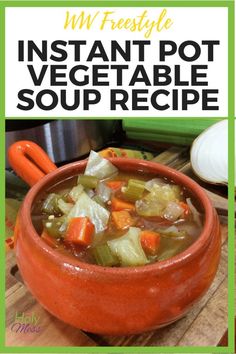 an orange bowl filled with vegetable soup on top of a wooden cutting board