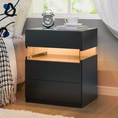 a night stand with a clock on it next to a window and a white rug