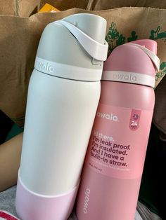 two pink and white water bottles sitting next to each other