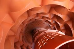 a close up view of an orange object with holes in the center and metal parts around it