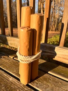 three rolls of toilet paper tied up on a wooden bench