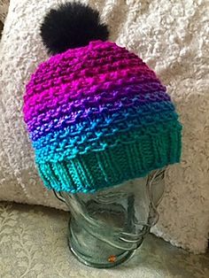 a knitted hat with a pom - pom sitting on top of a head