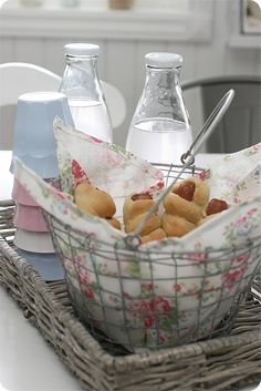 a basket filled with hot dogs and bottles of water