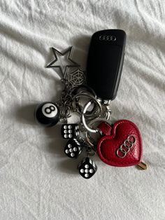 a cell phone and keychain laying on top of a bed